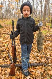 Child proudly displaying shot groundhog