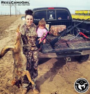 Mother holding baby and slaughtered coyote