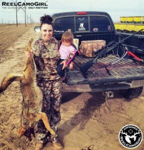 Mother holding baby and slaughtered coyote