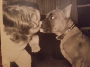 Suzyn as child and her dog exchanging a kiss